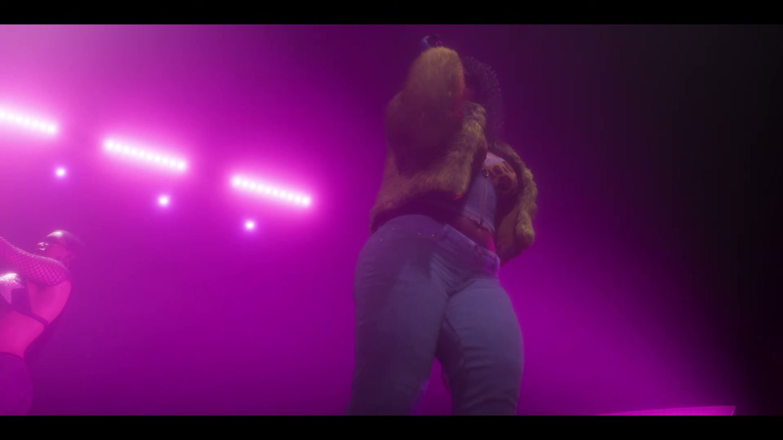 Une artiste sur une scène baignée de projecteurs roses, dans le trailer de lancement de GTA 6